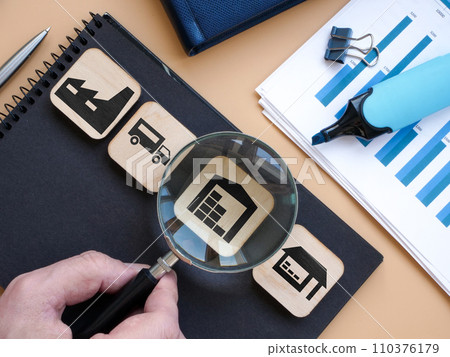 Product supply chain and warehouse. Hand holds a magnifying glass. 110376179