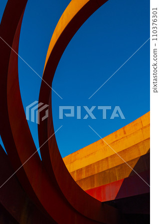 Abstract view of a modern sculptural architecture with vibrant red and yellow curves. 110376301