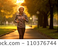 Sporty mature woman jogging in the park at sunrise 110376744
