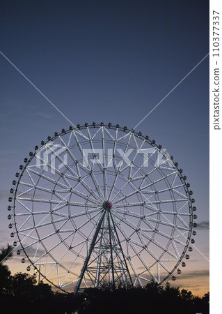 摩天輪在夕陽下閃閃發光 摩天輪在夕陽下閃閃發光 110377337