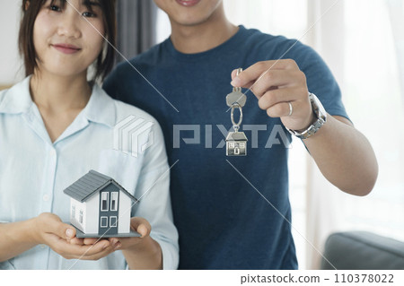 Happy young couple buying a new house receiving the keys. Happy young couple buying a new house receiving the keys. 110378022