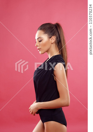 Woman in black bodysuit. Stylish lady isolated on pink. Sensual gorgeous young woman in black bodysuit posing. Woman in black bodysuit. Stylish lady isolated on pink. Sensual gorgeous young woman in black bodysuit posing. 110378234