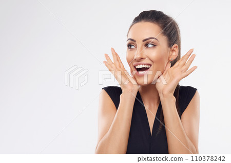Shocked and surprised girl screaming covering mouth her hands.Beautiful Woman in black dress.Presenting your product.Expressive facial expressions emotions Shocked and surprised girl screaming covering mouth her hands.Beautiful Woman in black dress.Presenting your product.Expressive facial expressions emotions 110378242
