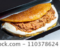 Venezuelan Cachapa with Pulled Meat on Black Plate in Restaurant 110378624