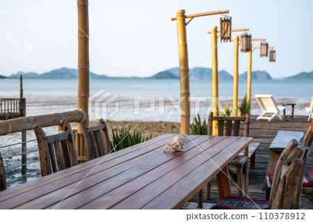 Outdoor seating and bar counter on the terrace, with view of the sea on the background 110378912