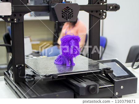 Model of toy lion printed on 3D printer from melted plastic purple color on desktop of 3D printer. Concept 3D printer, 3D printing, modeling prototyping three dimensional object. Innovative production 110379871