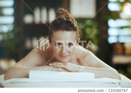 relaxed woman in massage cabinet laying on massage table relaxed woman in massage cabinet laying on massage table 110380787