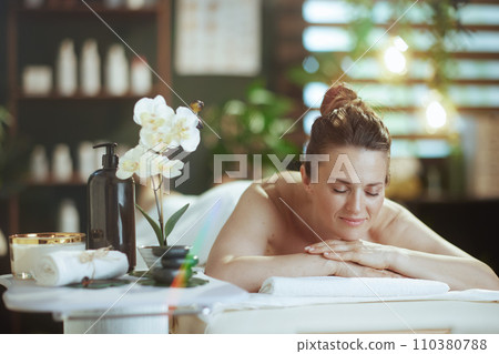 relaxed modern woman in massage cabinet laying on massage table relaxed modern woman in massage cabinet laying on massage table 110380788