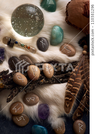 handmade stone runes on white fur 110381296