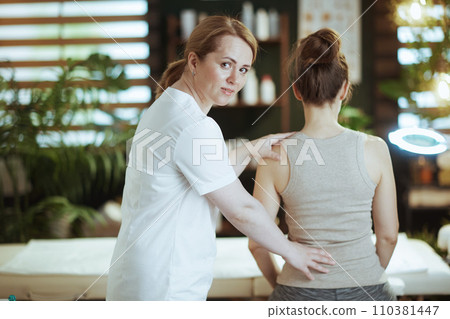 massage therapist checking clients back condition 110381447