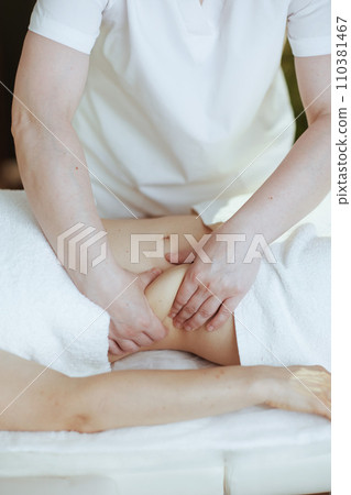 Medical massage therapist in spa salon massaging clients belly 110381467