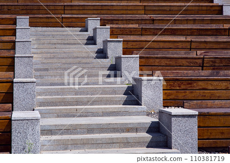 wooden benches along the granite stairs going up to the street theater on a sunny summer day, nobody. wooden benches along the granite stairs going up to the street theater on a sunny summer day, nobody. 110381719