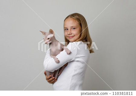 Happy young girl with cat pet on white background, studio portrait 110381811