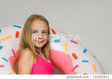 Sweet happy child girl with inflatable ring swimming float closeup. 110381812