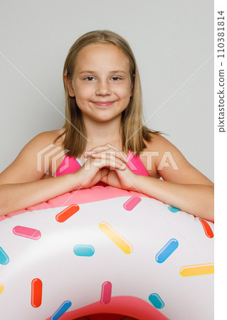 Joyful happy child girl with inflatable ring swimming float closeup.  110381814