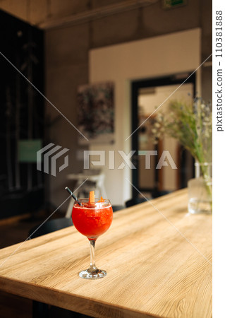 Orange cocktail with grapefruit, ice and rosemary in a transparent glass on a wooden table at style cafe 110381888