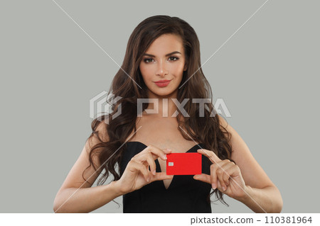 Beautiful brunette woman holding in her hand bank card solution 110381964