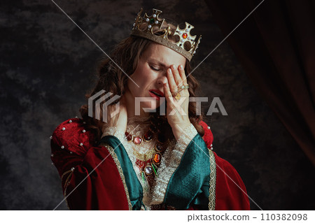 stressed medieval queen in red dress having neck pain stressed medieval queen in red dress having neck pain 110382098