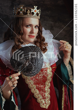 medieval queen in red dress with fan, white collar and crown medieval queen in red dress with fan, white collar and crown 110382101