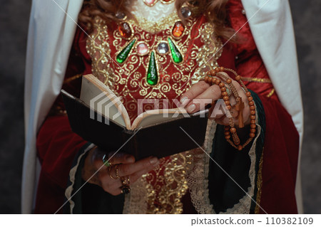 Closeup on medieval queen in red dress with book Closeup on medieval queen in red dress with book 110382109