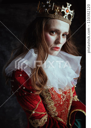 medieval queen in red dress with white collar and crown 110382120