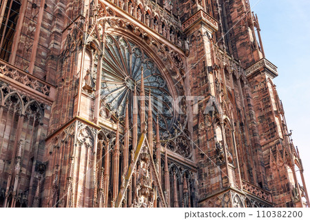 Close-up view of Cathedrale Notre Dame de Strasbourg in France Strasbourg city. Detail gothic architecture rose window stained glass facade wall of medieval historic church Alsace town sunny sky day 110382200