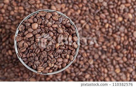 Roasted coffee beans in a metal jar top view. Coffee as background. 110382576