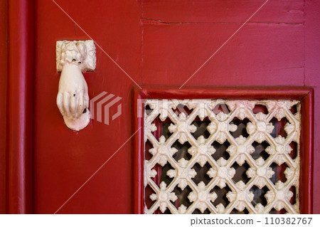 Red door with a white knocker and grating Red door with a white knocker and grating 110382767