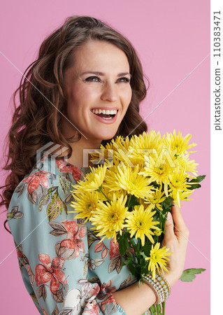 smiling modern woman in floral dress on pink 110383471