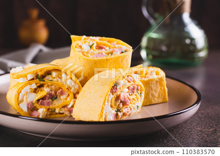 Tortilla rolls with salad of sausages, eggs, cheese and herbs on a plate Tortilla rolls with salad of sausages, eggs, cheese and herbs on a plate 110383570