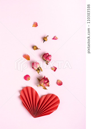 Folded red paper heart and dry flowers on a pink background vertical view 110383586