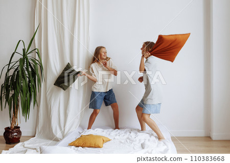 Two girls have a pillow fight 110383668