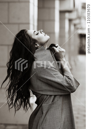 Woman in coat, urban outdoors. 110383670