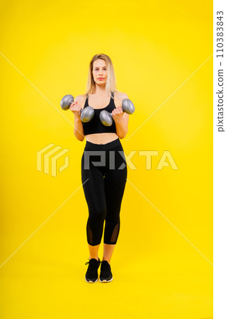 Athletic woman in sportswear raises dumbbells leads healthy lifestyle has happy expression Athletic woman in sportswear raises dumbbells leads healthy lifestyle has happy expression 110383843