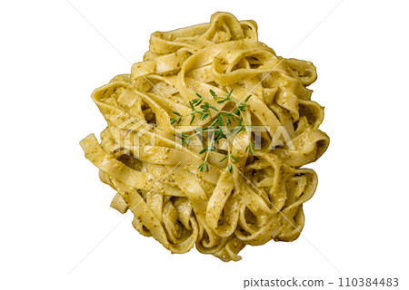 Delicious fresh pasta with pesto sauce, salt, spices and herbs on a ceramic plate 110384483