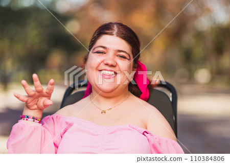 Hispanic Woman with cerebral palsy disability diversity, Portrait waving and greeting to camera 110384806