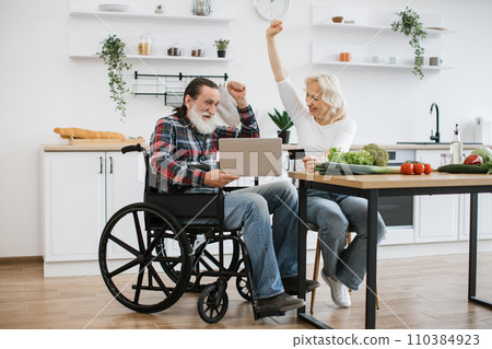 Caucasian couple, pretty wife and bearded man in wheelchair, pay for food with credit card. 110384923