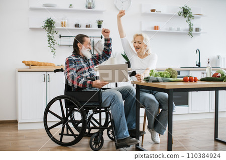 Caucasian couple, pretty wife and bearded man in wheelchair, pay for food with credit card. 110384924