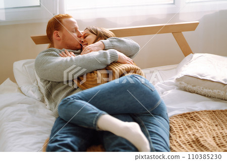 Couple in love relaxing at home on bed while they hug each other. Valentine's Day, holiday concept. Couple in love relaxing at home on bed while they hug each other. Valentine's Day, holiday concept. 110385230