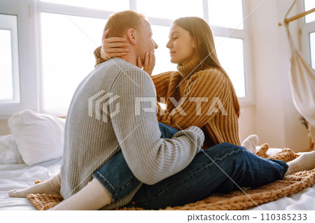 Couple in love relaxing at home on bed while they hug each other. Valentine's Day, holiday concept. Couple in love relaxing at home on bed while they hug each other. Valentine's Day, holiday concept. 110385233