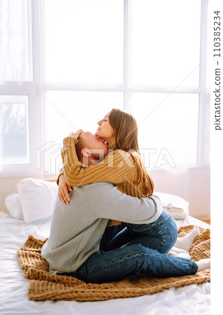 Couple in love relaxing at home on bed while they hug each other. Valentine's Day, holiday concept. Couple in love relaxing at home on bed while they hug each other. Valentine's Day, holiday concept. 110385234