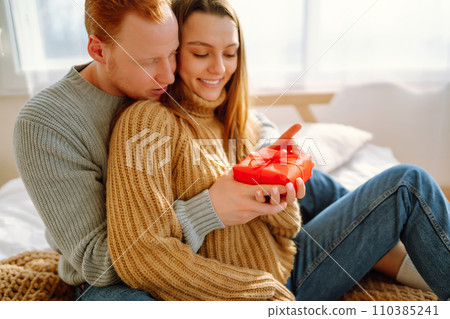 Valentine's Day concept. Exchange of gifts. Young couple at home celebrating Valentine's Day. 110385241