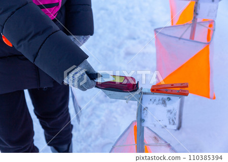 A competitor in an orienteering competition applies a wireless chip to the starting mark to start the countdown. 110385394