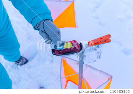 A competitor in an orienteering competition applies a wireless chip to the starting mark to start the countdown. A competitor in an orienteering competition applies a wireless chip to the starting mark to start the countdown. 110385395