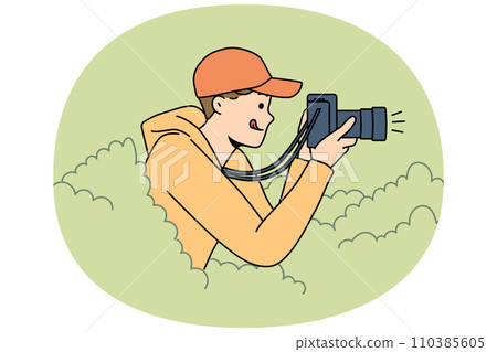 Young man reporter hide in bushes make pictures Young man reporter hide in bushes make pictures 110385605