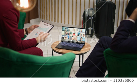 Businessmen presents ideas on videocall, using online telework meeting with investors or shareholders to develop management plan. Startup team attends remote conference on laptop. Handheld shot. 110386800