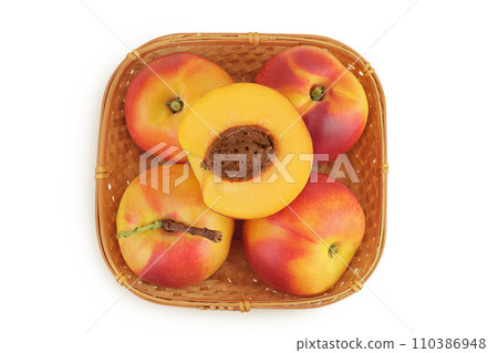 Ripe nectarine fruit with half in a wicker basket isolated on white background with full depth of field. Top view. Flat lay Ripe nectarine fruit with half in a wicker basket isolated on white background with full depth of field. Top view. Flat lay 110386948