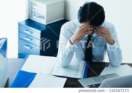 Businessman tired from working long hours 110387273