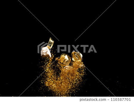 Gold Ingot Chinese Money bar token fly with dust particle in air. Chinese new year Yuanbao gold ingots floating to golden money sand particle. Language is wealthy prosperity. Black background isolated 110387701