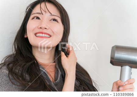 女人用吹風機吹乾頭髮（護髮） 110389866